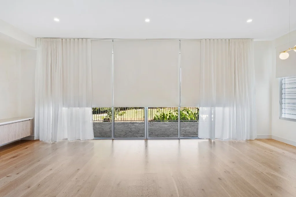 Roller blinds with sheer curtains in a modern living room